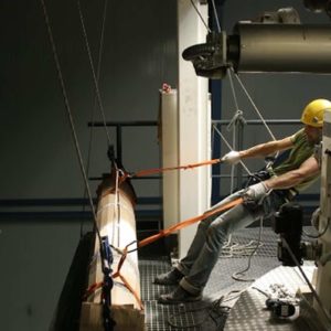 Transport wysokościowy wałka zwrotnego maszyny do produkcji rękawa z polietylenu przy użyciu technik linowych.