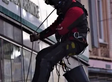Prace na wysokości - montaż reklamy wielkoformatowej, przy zastosowaniu technik alpinistycznych, na budynku sklepu "Zenit" w Katowicach.
