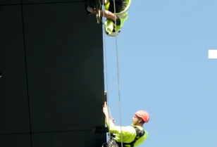 Prace wysokościowe - montaż płyt HPL na elewacji głównej w technikach alpinistycznych