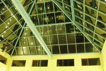 Mycie wewnętrznej i zewnętrznej powierzchni świetlika w kształcie piramidy przy wykorzystaniu technik alpinistycznych.