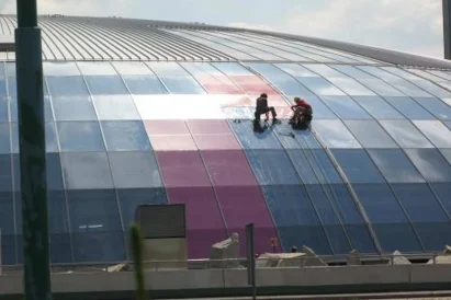 Wyklejanie reklamy na szklanej elewacji kopuły Ronda Sztuki.