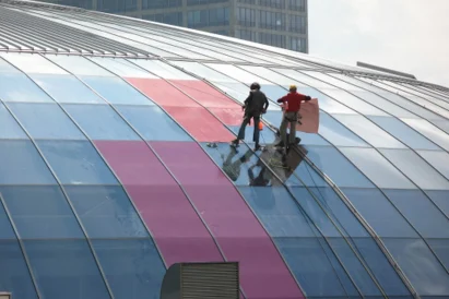 Wyklejanie reklamy na szklanej elewacji kopuły Ronda Sztuki.