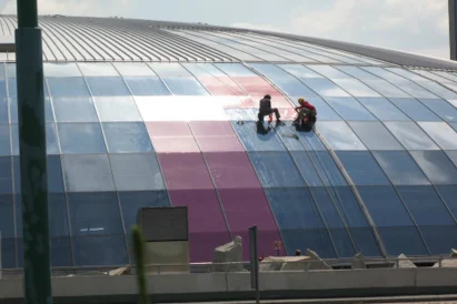 Wyklejanie reklamy na szklanej elewacji kopuły Ronda Sztuki.