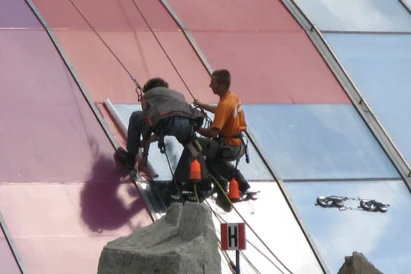 Wyklejanie reklamy na szklanej elewacji kopuły Ronda Sztuki.