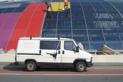 Wyklejanie reklamy na szklanej elewacji kopuły Ronda Sztuki.