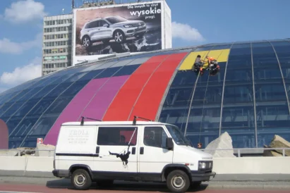 Wyklejanie reklamy na szklanej elewacji kopuły Ronda Sztuki.