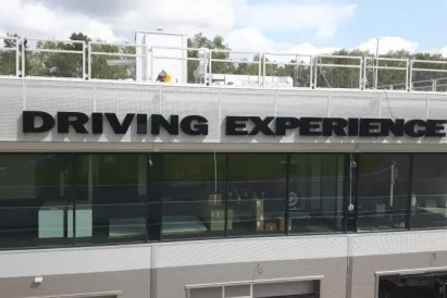 Wykonanie liter z aluminium i plexi oraz montaż napisu Porsche Driving Experience na fasadzie budynku