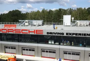 Wykonanie liter z aluminium i plexi oraz montaż napisu Porsche Driving Experience na fasadzie budynku