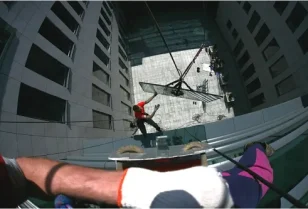 Transport wysokościowy szyby elewacyjnej przy użyciu technik linowych.